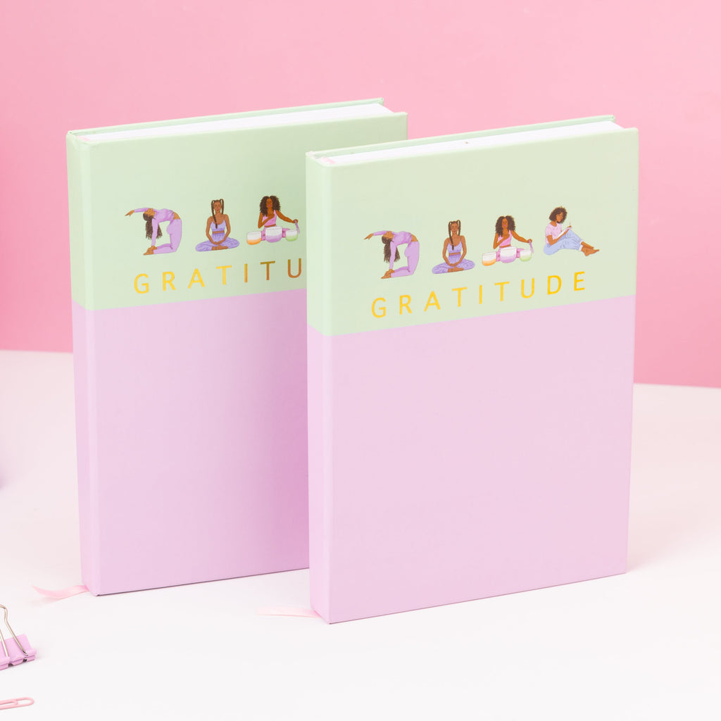 Two pink notebooks with 'Gratitude' text on a pink background